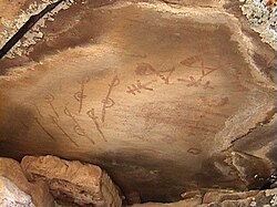 Native American rock painting close to Douglas, Wyoming, USA. One possible interpretation of this painting is: On the left side a group of United States Army soldiers with different insignia and on the right side Native Americans are shown[citation needed]