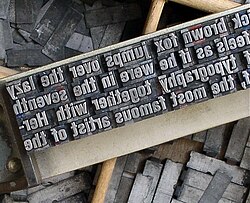 Metal type sorts arranged on a composing stick