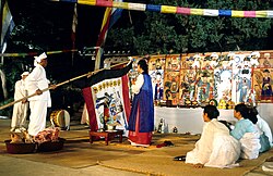 White and blue-clothed people performing a ritual