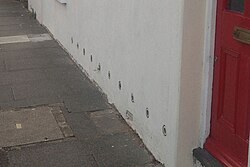 Porous tubes used to treat rising damp are visible on the outside of this Victorian house.