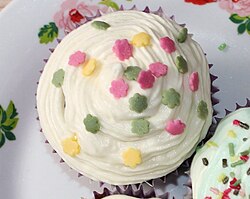 A cupcake topped with the sprinkle type of confetti candy