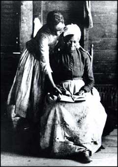 Former slave reading, 1870. After slavery ended, illiteracy rates among black people dropped from 80% in 1870 to 30% in 1910.[273]