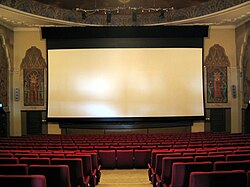 Film audiences are typically seated in comfortable chairs arranged in close rows before a projection screen. Norway (2005)