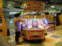 Western Dream, one example of a push medal game. If a player manages to get all red lights on, lights flash and a train stops at his/her side. The train tilts its tender full of coins, dumping them into the player's platform.