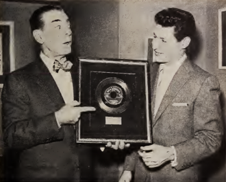 Eddie Cantor handing Eddie Fisher a gold record for Fisher's single "Oh! My Pa-Pa" on January 6, 1954.