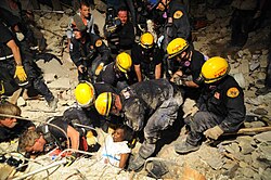 A woman is rescued alive from rubble several days after the initial quake.