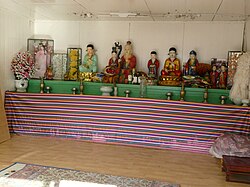 Shrine holding vases of flowers and statues of various humanoid deities