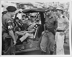 American, Australian, and New Zealand military police with a civilian police officer in Saigon during the Vietnam War, 1965