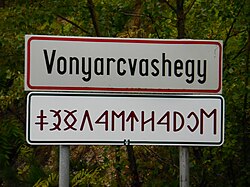 Street sign with a transcription to the runic writing system, used before Saint Stephen's State formation