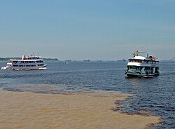 Meeting of Waters; the confluence of Rio Negro (blue) and Rio Solimões (sandy) near Manaus, Brazil