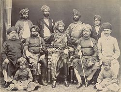 The Nawab of Junagadh Bahadur Khan III (seated centre in an ornate chair) shown in an 1885 photograph with state officials and family