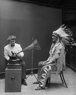 Ethnomusicologist Frances Densmore at the Smithsonian Institution in 1916 where she was recording Blackfoot chief Mountain Chief for the Bureau of American Ethnology. In this picture, Mountain Chief is listening to a recording.