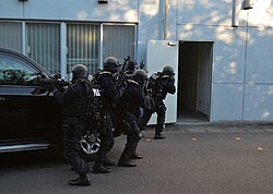 Japanese prefectural police Special Assault Team members preparing to enter a building