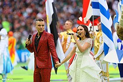 Soprano Aida Garifullina and pop singer Robbie Williams singing "Angels" at the opening ceremony