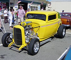 3-window highboy Deuce coupé with a traditional chop—dropped front axle, sidepipes, bugcatcher scoop (with Mooneyes cover) over dual quads on a tunnel ram—as well as less-traditional shaved door handles and disc brakes