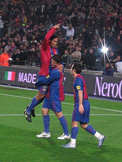 Giuly celebrating a goal against Real Sociedad with Ronaldinho and Juliano Belletti.
