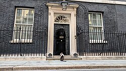 The main entrance of 10 Downing Street, the official residence and office of the First Lord of the Treasury, who is by custom nowadays also the Prime Minister. Also seen is Larry the Cat.