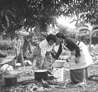 Women dressed for a funeral, cooking for the mourners