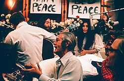 Recording "Give Peace a Chance". Left to right: Rosemary Leary (face not visible), Tommy Smothers (with back to camera), John Lennon, Timothy Leary, Yoko Ono, Judy Marcioni and Paul Williams, June 1, 1969.