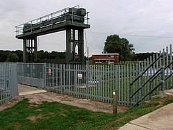 The sluice which controls flow from the River Wissey into the cut-off channel, with a pumping station in the background