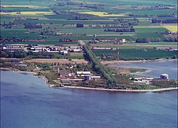 The former Risø National Laboratory on the edge of Roskilde Fjord, which was the site of Denmarks only nuclear reactors between 1957 and 2003. The two outermost cylindrical buildings on the peninsula contained the reactors DR-2 and DR-3.