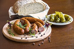 Kielbasa sausage, a staple of Polish cuisine, with pickled cucumbers and rye bread