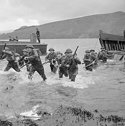 Men of the 1st Battalion, Queen's Own Royal West Kent Regiment wade ashore from landing craft during combined operations training in Scotland, 17 November 1942.