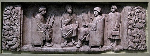 A teacher with two students, as a third arrives with his loculus, a writing case[473]