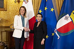 Roberta Metsola and President Myriam Spiteri Debono meeting on 20 April 2024, with the flags of Malta, the European Union, and the presidential standard in the background.