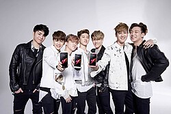 iKon debuted in 2015. Their 2018 single, "Love Scenario", broke several records at the time; including the longest run as the top-charting song, the most hours of 'perfect all-kills,' and the first song to be certified Platinum by the KCMA.