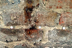 Damp-proofing rods installed along a mortar course to treat rising damp by forming a damp-proof course (DPC)