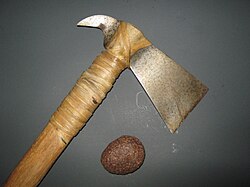 A meteorite and a hatchet that was forged from meteoric iron. Evidence of the Widmanstätten patterns from the original meteorite used to make the hatchet's head can be seen on its surface.