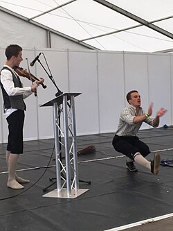 A traditional Welsh stepdance at the 2017 National Eisteddfod in Bodedern. The dancer and musician are both wearing traditional male folk costumes.