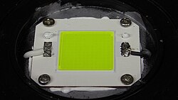 An 80W Chips on board (COB) LED module from an industrial light luminaire, thermally bonded to the heat sink