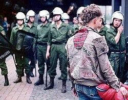 A punk faces a line of riot police at the 1984 Chaos Days