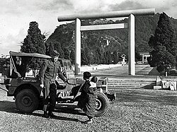 A young Korean girl carrying a baby, speaking to a U.S. soldier in front of Chōsen Shrine in Seoul (1945)