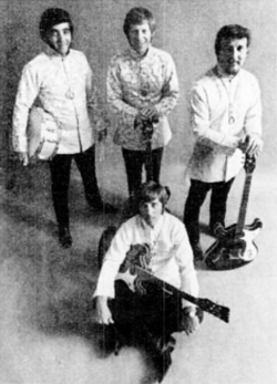 The 1968—1972 of The Ventures. Standing from left to right: Mel Taylor, Bob Bogle, and Don Wilson. Gerry McGee is sitting.