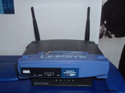 A Linksys wireless router sitting atop a Comcast cable modem in a home setting (2006)