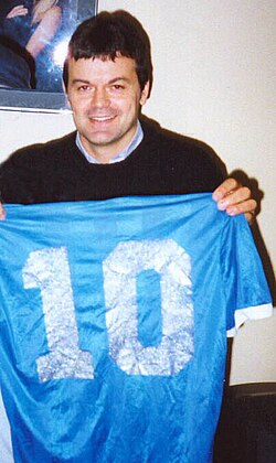 Steve Hodge posing with the jersey worn by Maradona in the match, which he swapped with him