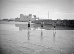 Walter Mittelholzer's traveling companions playing ball on the beach of Cape Juby, image between 1930 and 1931, during Spanish protectorate in Morocco
