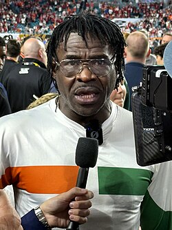 Irvin was a highly visible booster of the Miami Hurricanes football team during the 2025-26 season, here talking on the sideline before their appearance in the 2026 CFP national championship