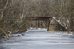 View of a bridge that connects the train route for the Dinky, the Stony Brook that flows underneath being frozen in wintertime