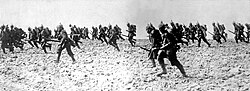 A black and white image of numerous soldiers charging to the left