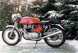 A vintage Triton motorcycle consisting of a Triumph twin-cylinder engine in a Norton Featherbed frame built in a street legal racer style with single seat, clip-on low handlebars and megaphone exhausts.