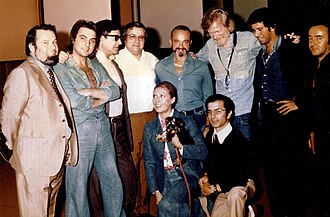 Astor Piazzolla with Gerry Mulligan at the Summit recording, Milan (Italy) 1974. The image includes the producer Aldo Pagani [it], first from the left, and some performers, including Pino Presti, second from right, and Tullio De Piscopo, second from left