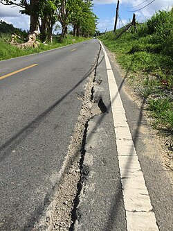 Road damage from an electrical fire caused by energized fallen power line caused by Hurricane Maria in Puerto Rico