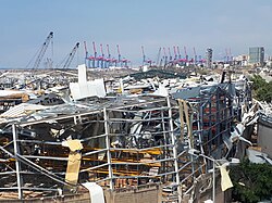 Warehouse damaged by the 4 August 2020 explosion, with container terminal gantry cranes in the background