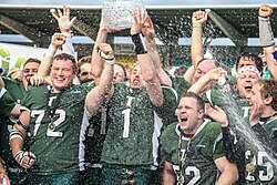 Belfast Trojans players hoisting the Shamrock Bowl in 2012, marking their first of five titles in the 2010s.