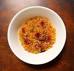 Cooked Shin Ramyun. The carrot pieces are printed with the hanja character 辛 (shin)