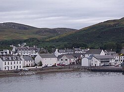 A view of buildings along Shore Street, with Loch Broom in foreground